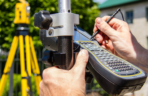 man surveying land using a device